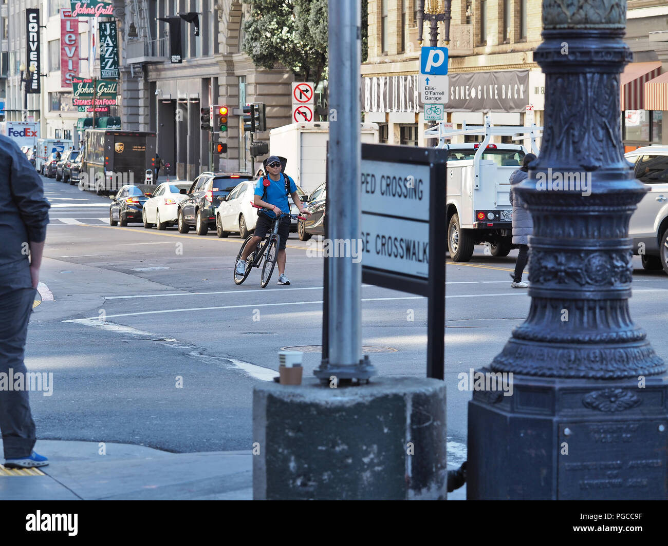 Bicyclist waiting on red light on a San Francisco street. February 2018 Stock Photo