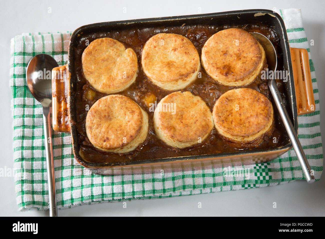 Savoury/Savory minced Beef stew topped with cheese scones in an oven proof roasting dish. Beef cobbler Stock Photo