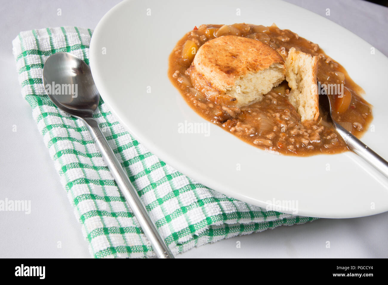 An English pub dish of beef cobbler. Savoury minced beef stew topped with cheese scone. Stock Photo