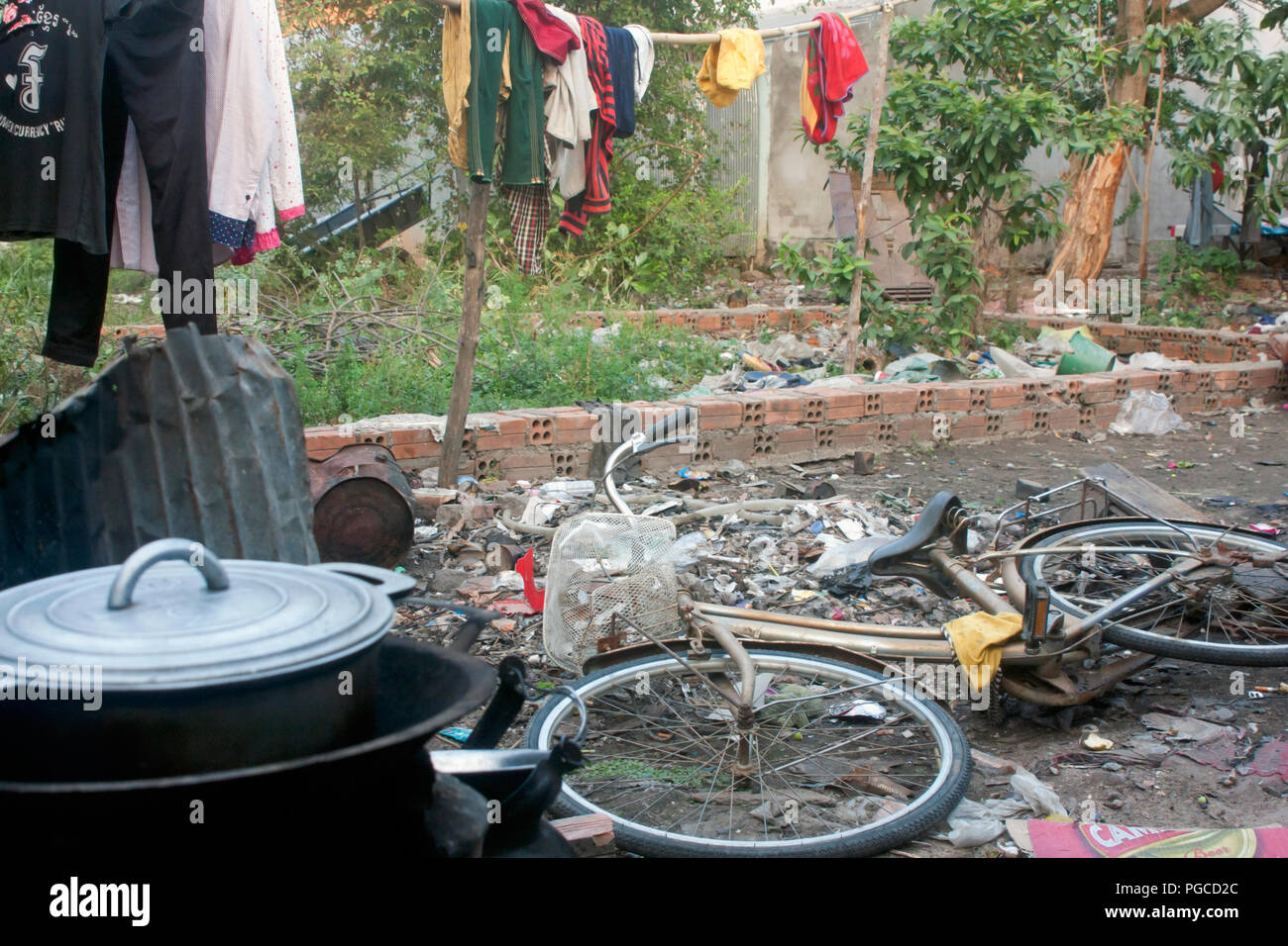 A common area used as a yard is littered with garbage in a slum area in Kampong Cham, Cambodia. Stock Photo