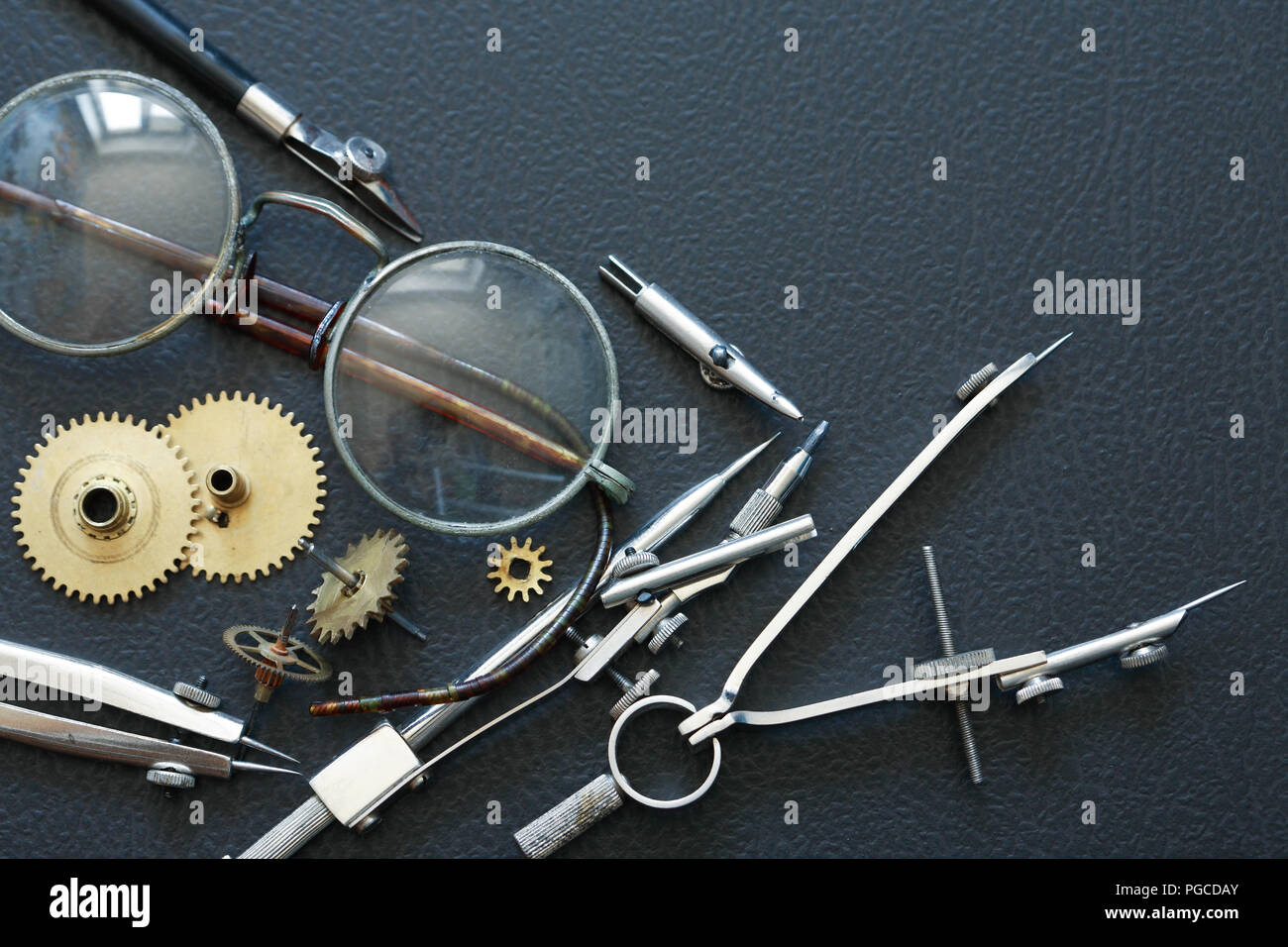 Engineering concept. Set of gears near divider and old spectacles Stock Photo