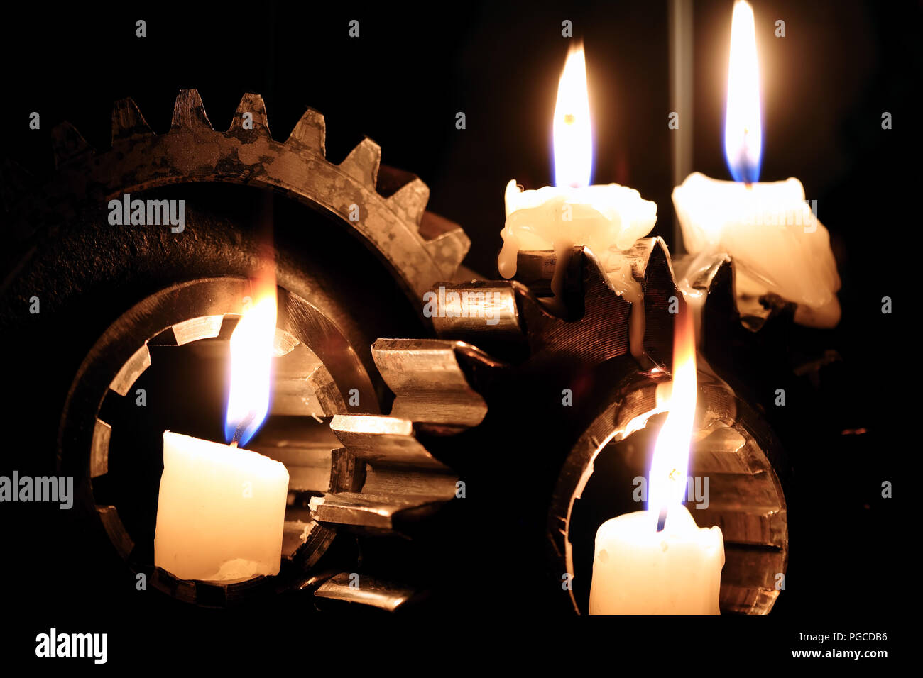 https://c8.alamy.com/comp/PGCDB6/lighting-candles-between-old-gears-against-dark-background-PGCDB6.jpg