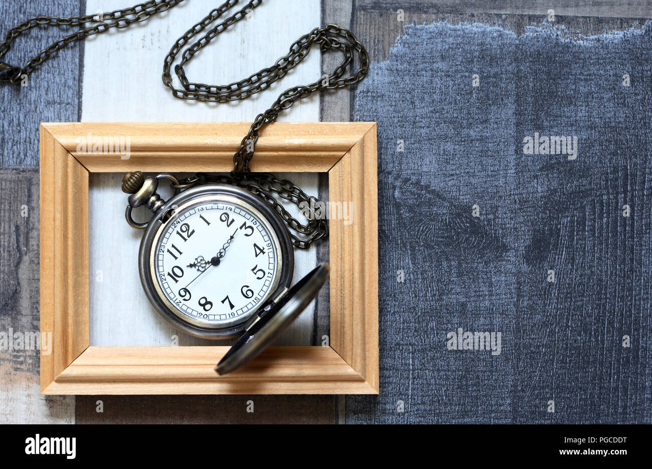 Vintage still life with old pocket watch inside wooden picture frame Stock Photo