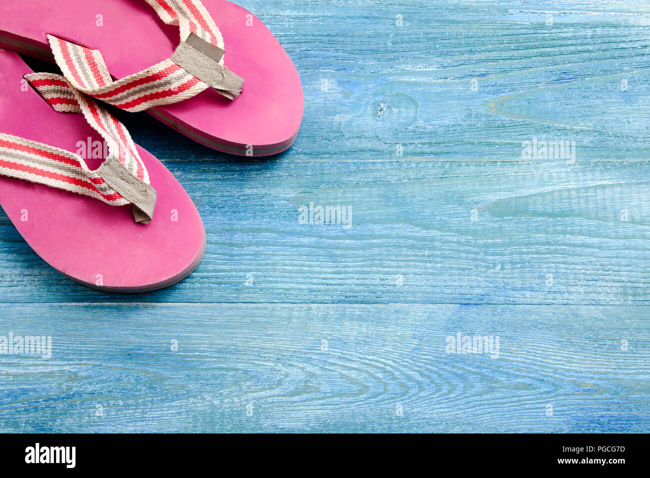 Pink slippers on a blue wooden background, summer background and ...