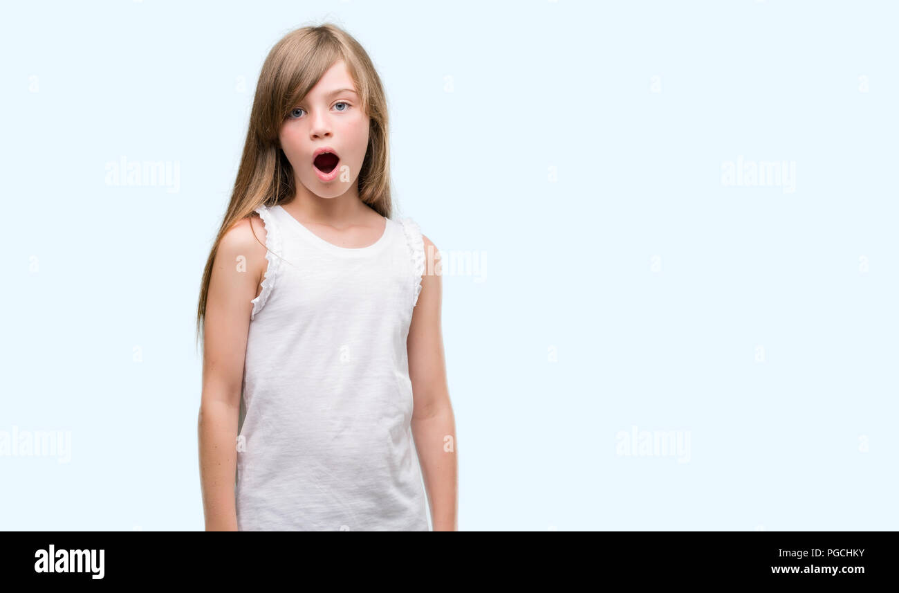 Young blonde toddler scared in shock with a surprise face, afraid and ...