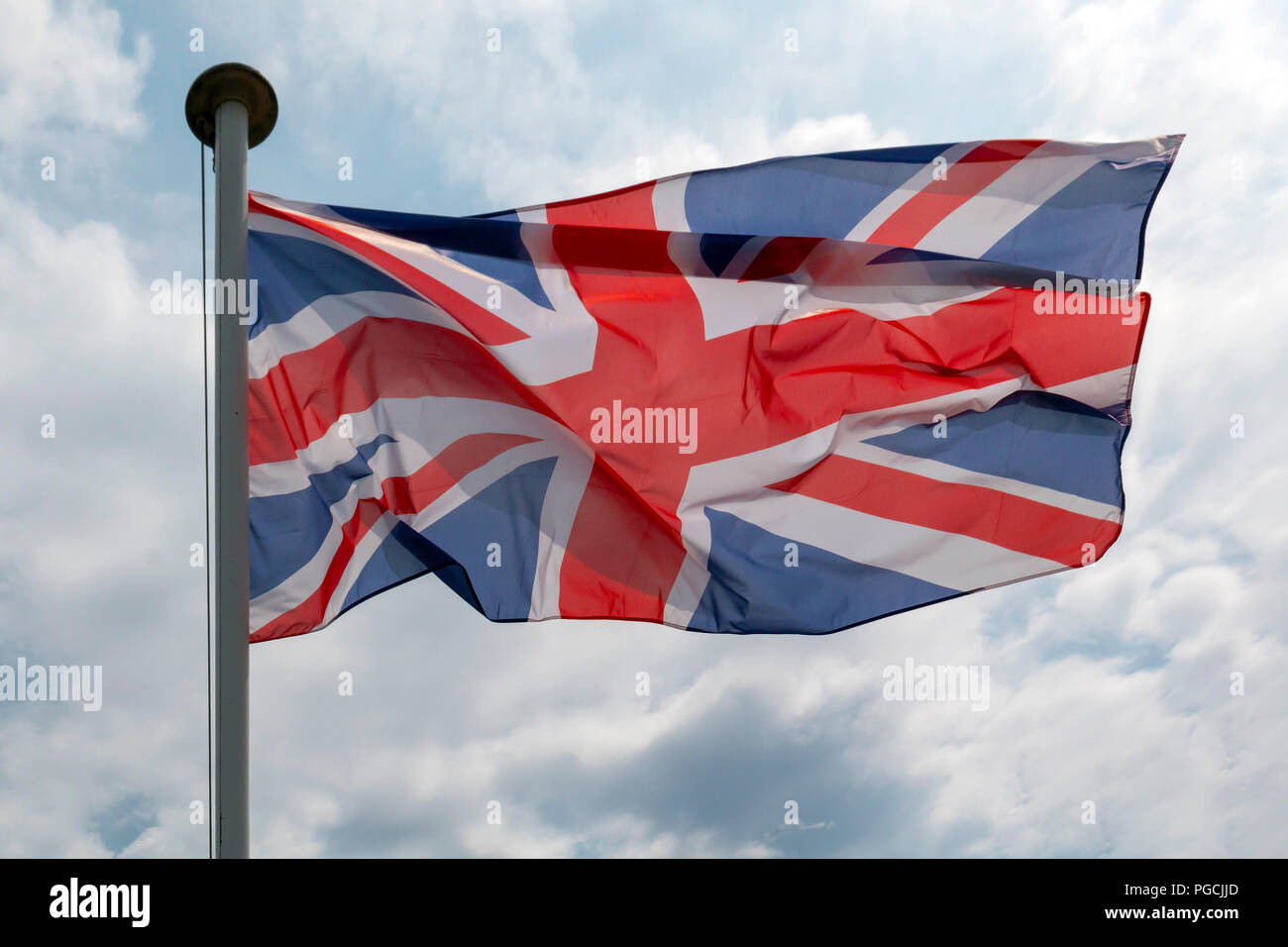 British Union Jack flag flying against a cloudy sky Stock Photo - Alamy