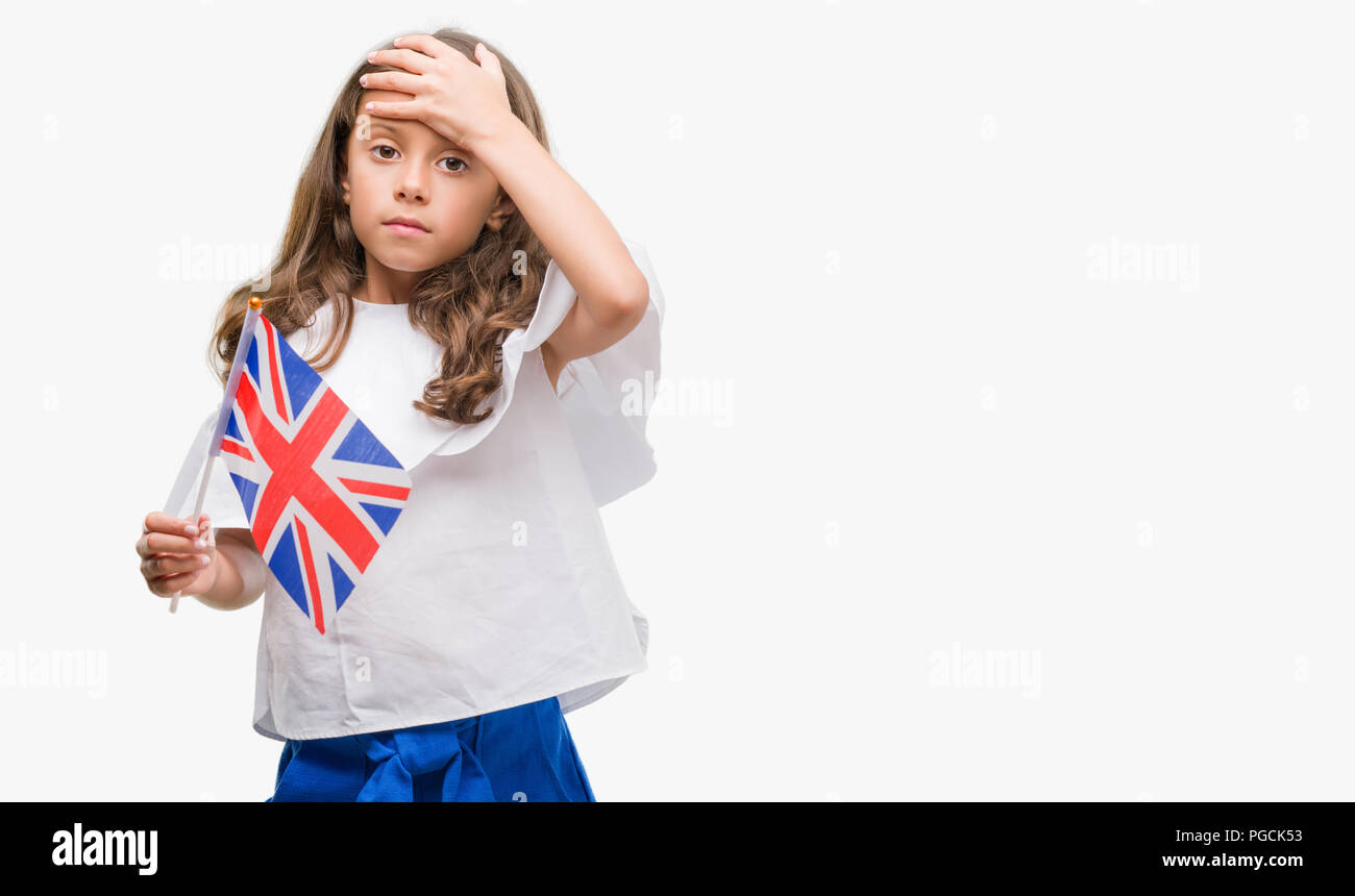 Brunette hispanic girl holding flag of United Kingdom stressed with hand on head, shocked with shame and surprise face, angry and frustrated. Fear and Stock Photo