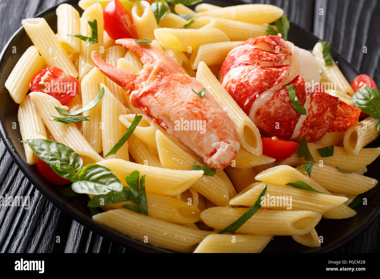 Delicious penne pasta with red lobster meat, tomatoes and fresh herbs