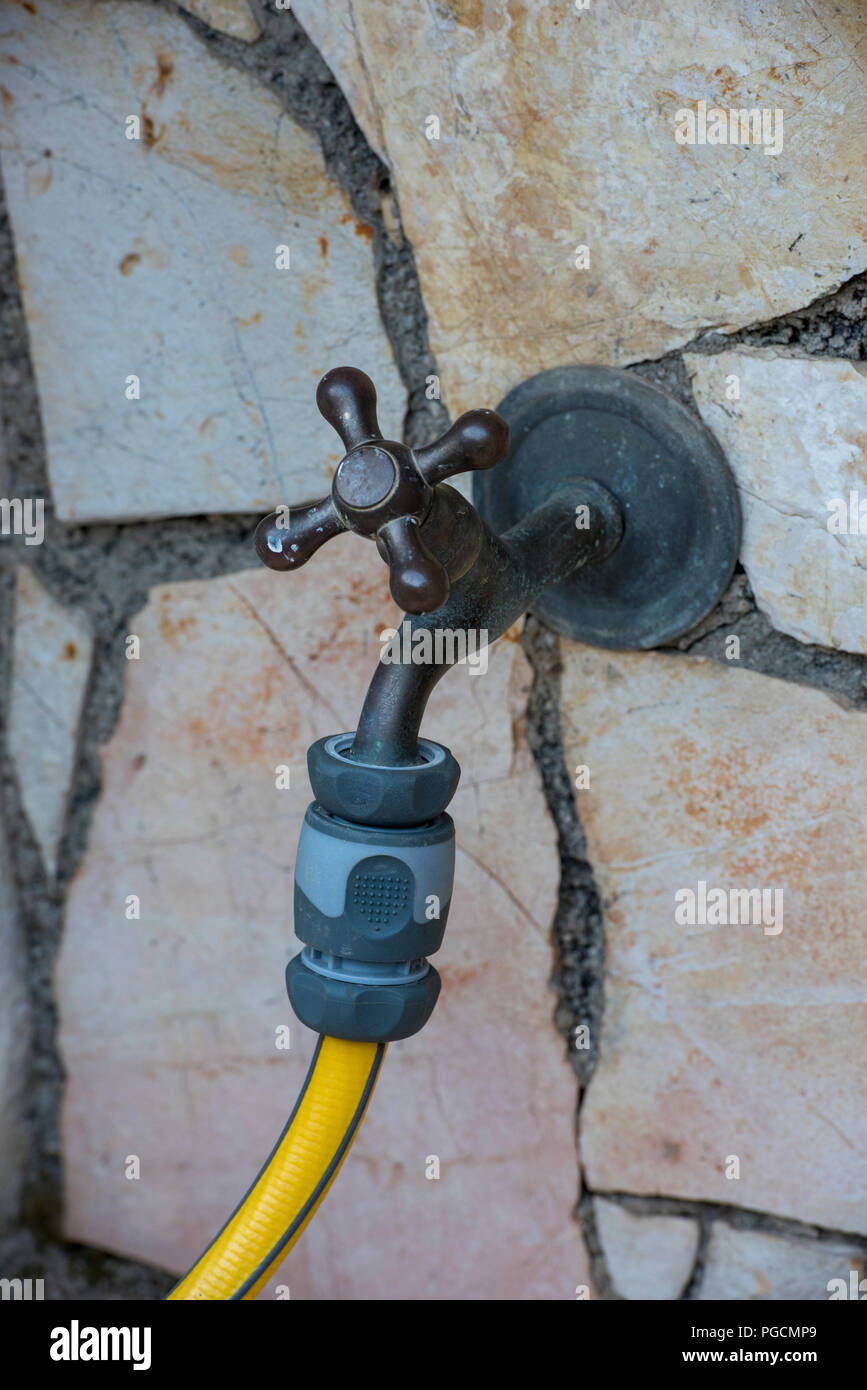 a traditional style brass tap or faucet on a wall outside of a house
