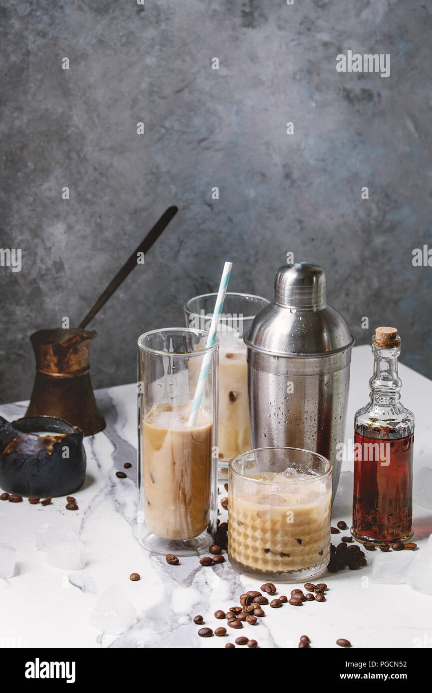 https://c8.alamy.com/comp/PGCN52/iced-coffee-cocktail-or-frappe-with-ice-cubes-and-cream-in-different-glasses-with-jezva-silver-shaker-bottle-of-rum-coffee-beans-around-on-white-ma-PGCN52.jpg