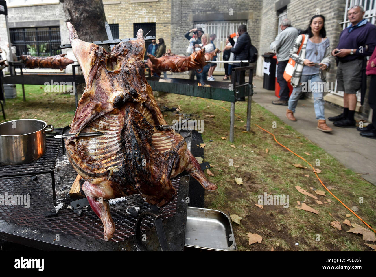 London, UK. 25 August 2018. A sheep is roasted using the Argentinian