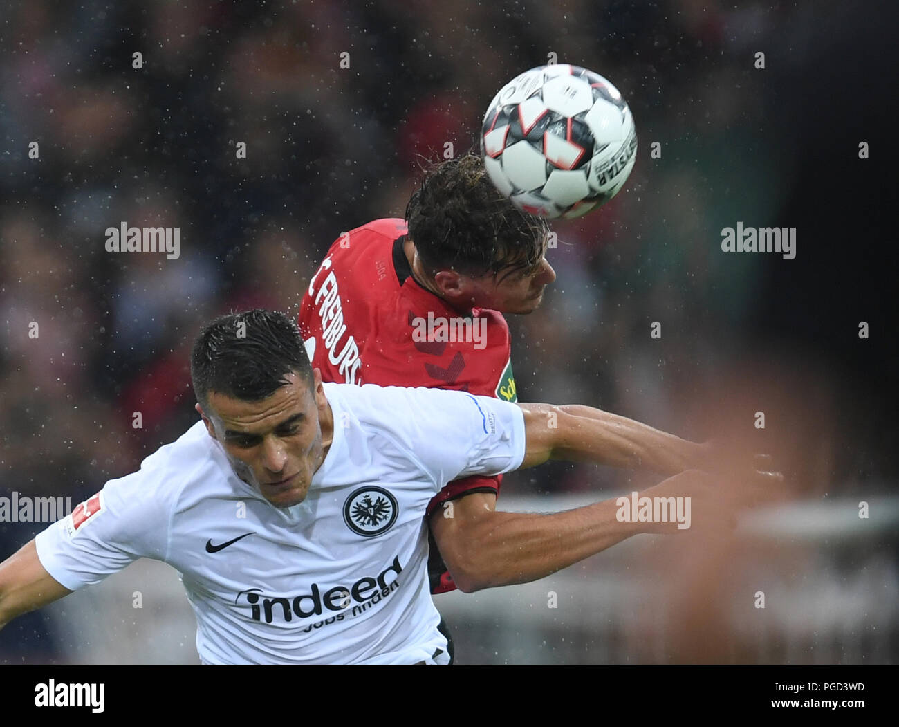 Freiburg, Germany. 25th Aug, 2018. Soccer, Bundesliga, SC Freiburg vs Eintracht Frankfurt, 1st matchday in the Schwarzwaldstadion. Marco Fabian (L) from Frankfurt and Manuel Gulde (R) from Freiburg vie for the ball. Credit: Patrick Seeger/dpa - IMPORTANT NOTICE: DFL regulations prohibit any use of photographs as image sequences and/or quasi-video./dpa/Alamy Live News Stock Photo