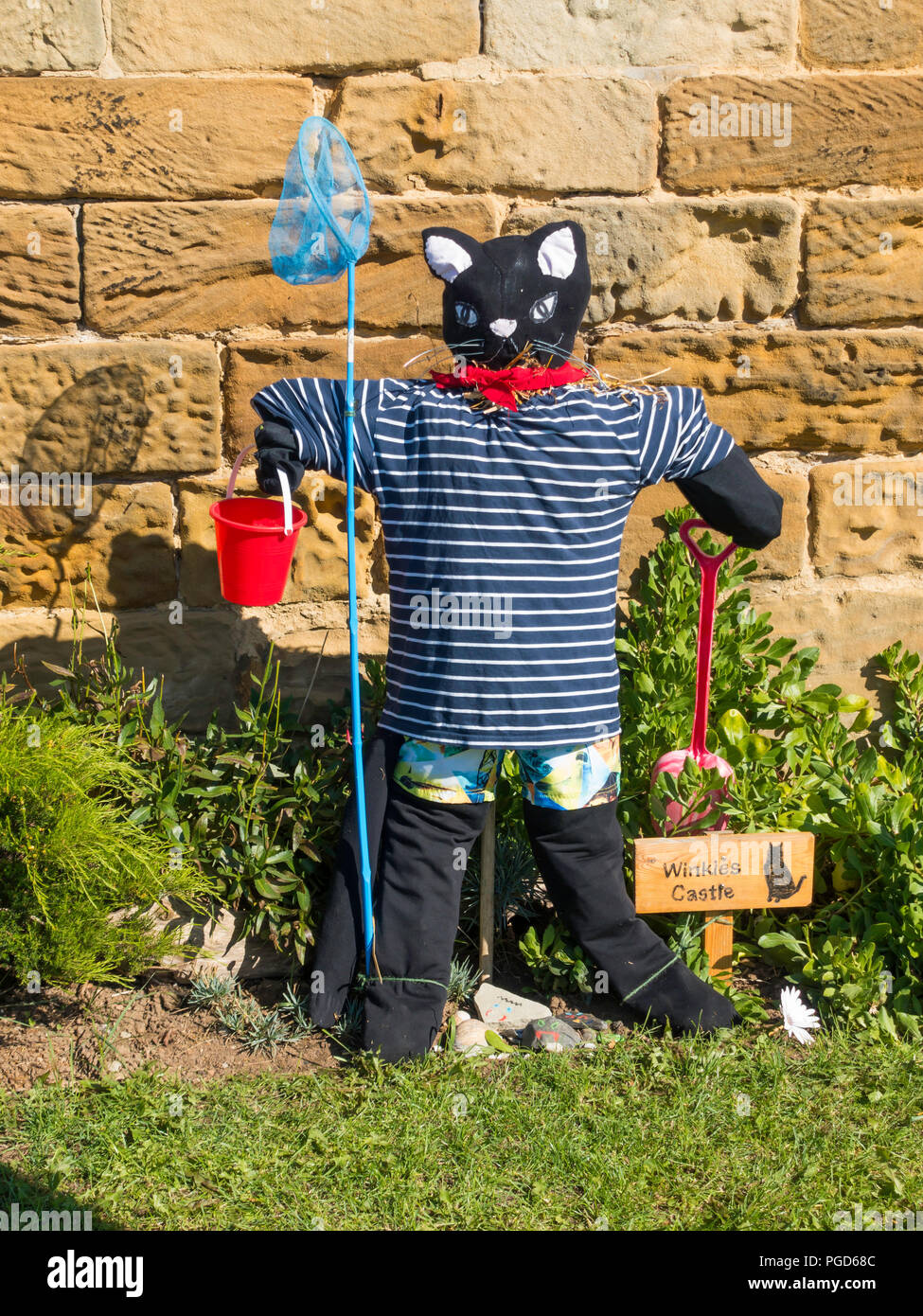 Marske North Yorkshire August 25th/ Like many Yorkshire villages Marske by the Sea has a weeklong Scarecrow Festival which started today 25th August,  many different organisations and social groups have made scarecrows an erected them around the village.  Parents and children can get a trail map to follow and view all the exhibits.  There is a prize draw at the end of the week. This cat is by the local Folk Museum  Winkies Castle in a former cobblers shop it had a cat called Winkie Credit: Peter Jordan NE/Alamy Live News Stock Photo