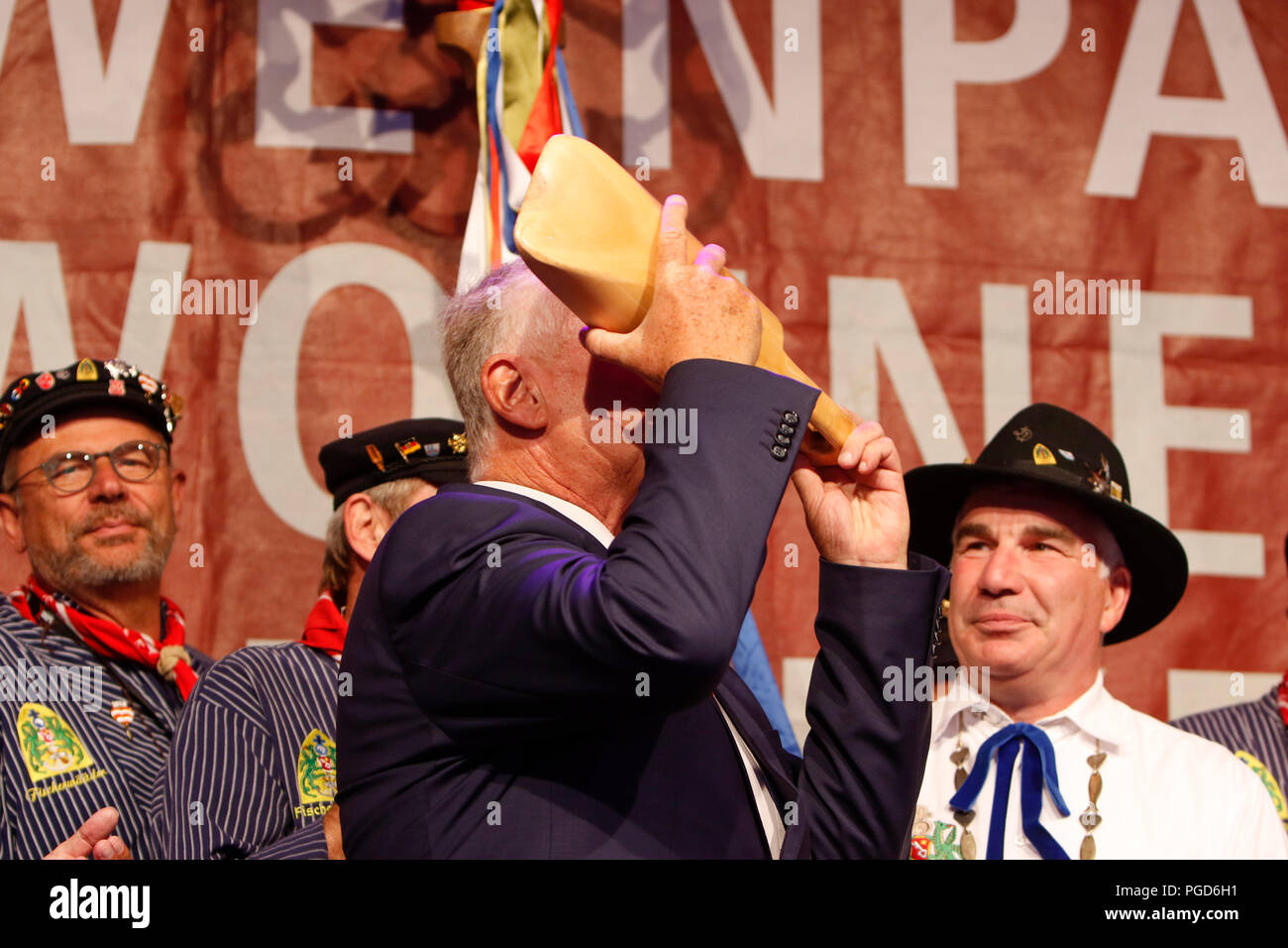 Worms, Germany. 25th August 2018. The Lord Mayor of Worms, Michael Kissel, drinks wine from the traditional Handnirsch (wooden ladle) at the opening ceremony. The largest wine and funfair along the Rhine, the Backfischfest started in Worms with the traditional handing over of power from the Lord Mayor to the mayor of the fishermen’s lea. Credit: Michael Debets/Alamy Live News Stock Photo