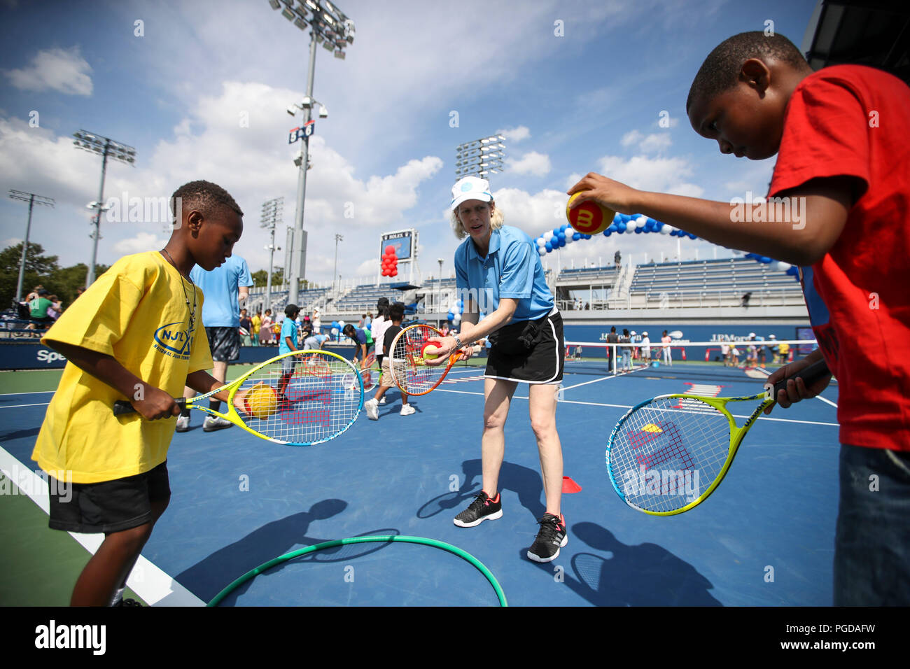 New York, USA. 25th Aug, 2018. A staff trainer teaches tennis technique to kids during the Arthur Ashe Kids' Day of the U.S. Open in New York, the United States, Aug. 25, 2018. Credit: Wang Ying/Xinhua/Alamy Live News Stock Photo