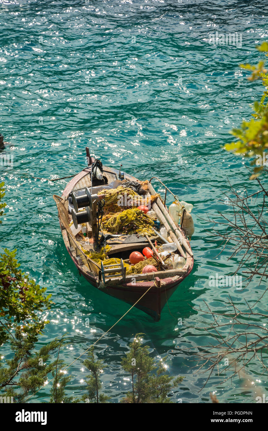 Old wooden fisher boat Inside the boat you can see a wooden mast and paddles plus fishing equipment Stock Photo