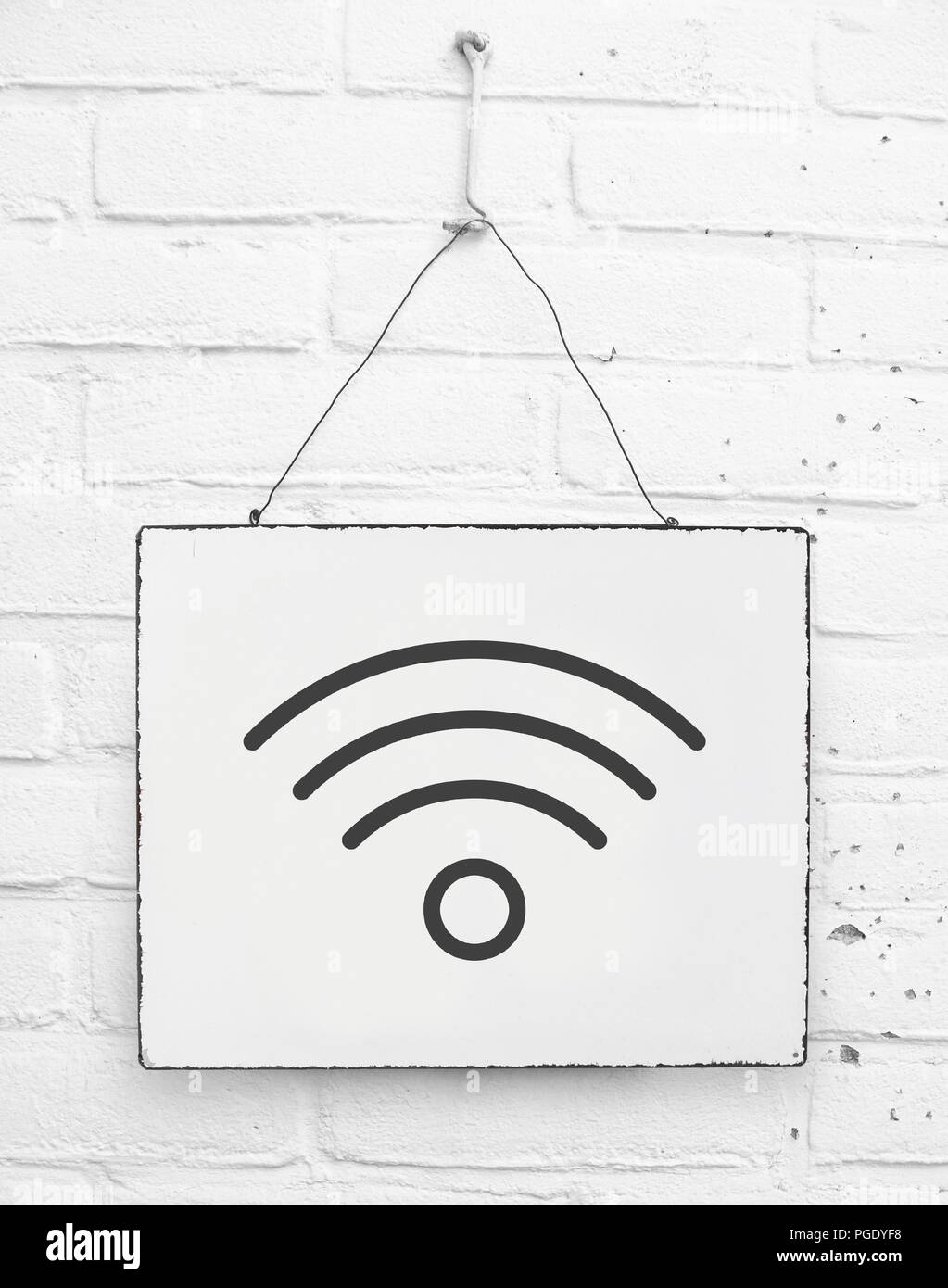 Wifi zone symbol sign on hanging board on white brick wall hotel restaurant Stock Photo