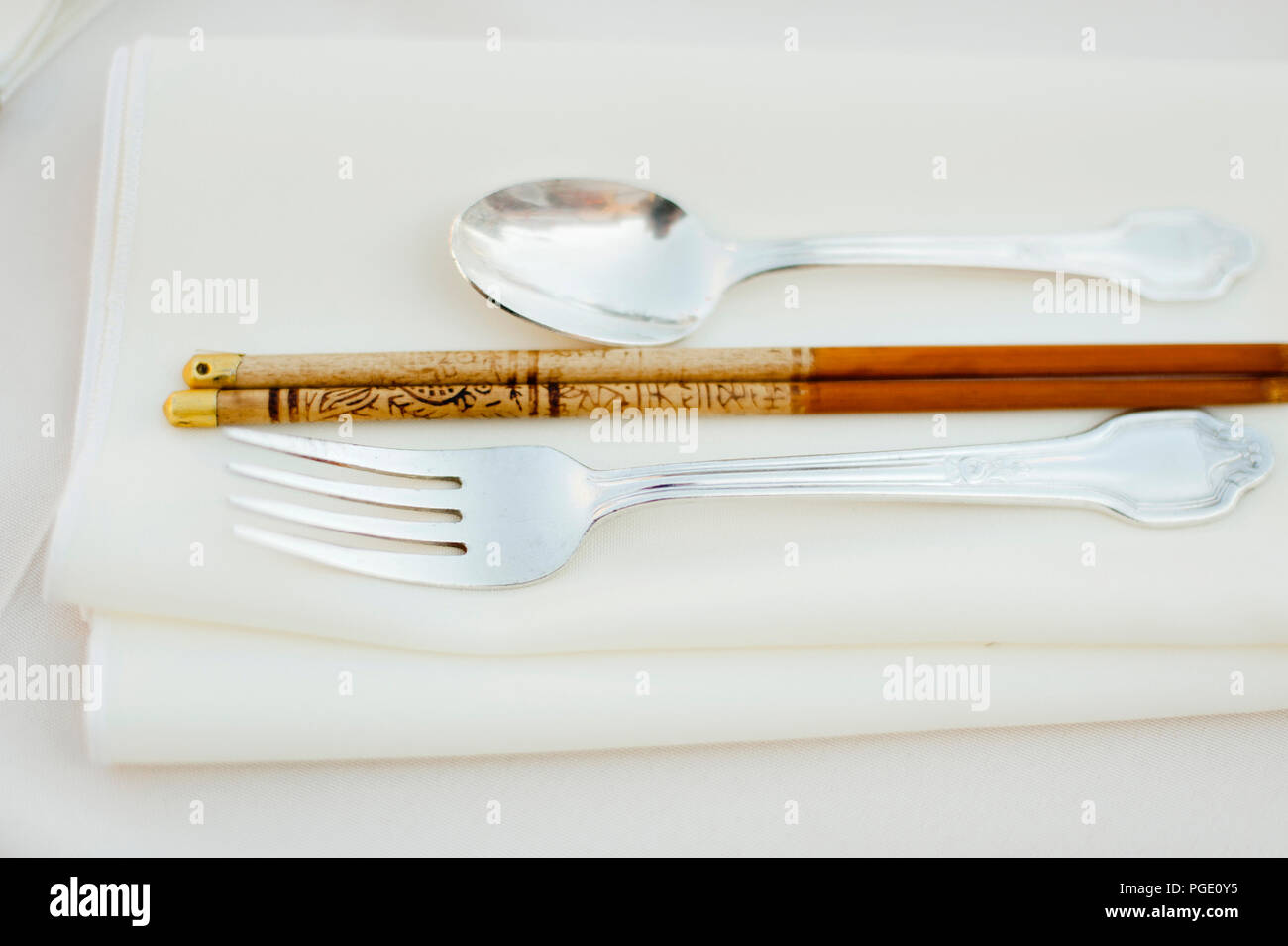 Silver fork and spoon with chopstick on a napkin Stock Photo