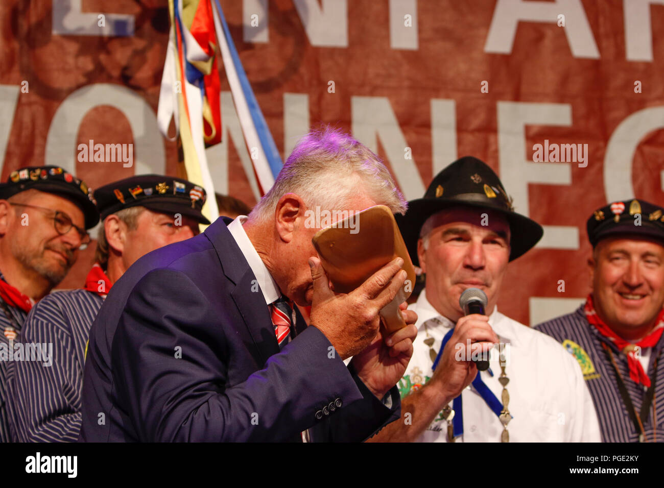 Worms, Germany. 25th Aug, 2018. The Lord Mayor of Worms, Michael Kissel, drinks wine from the traditional Handnirsch (wooden ladle) at the opening ceremony. The largest wine and funfair along the Rhine, the Backfischfest started in Worms with the traditional handing over of power from the Lord Mayor to the mayor of the fishermen's lea. The ceremony was framed by dances and music. Credit: Michael Debets/Pacific Press/Alamy Live News Stock Photo