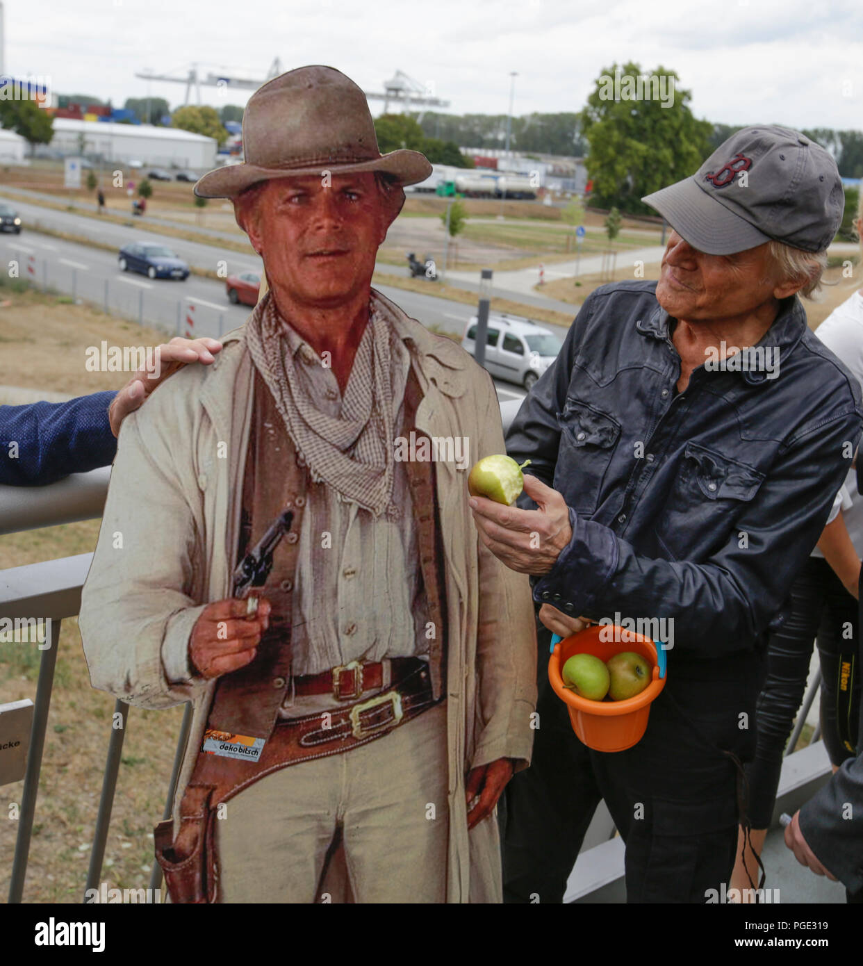 Worms, Germany. 24th Aug, 2018. Terence Hill poses with a cardboard cut-out of Terence Hill. Italian actor Terence Hill visited the German city of Worms, to present his new movie (My Name is somebody). Terence Hill added the stop in Worms to his movie promotion tour in Germany, to visit a pedestrian bridge, that is unofficially named Terence-Hill-Bridge (officially Karl-Kubel-Bridge). Credit: Michael Debets/Pacific Press/Alamy Live News Stock Photo
