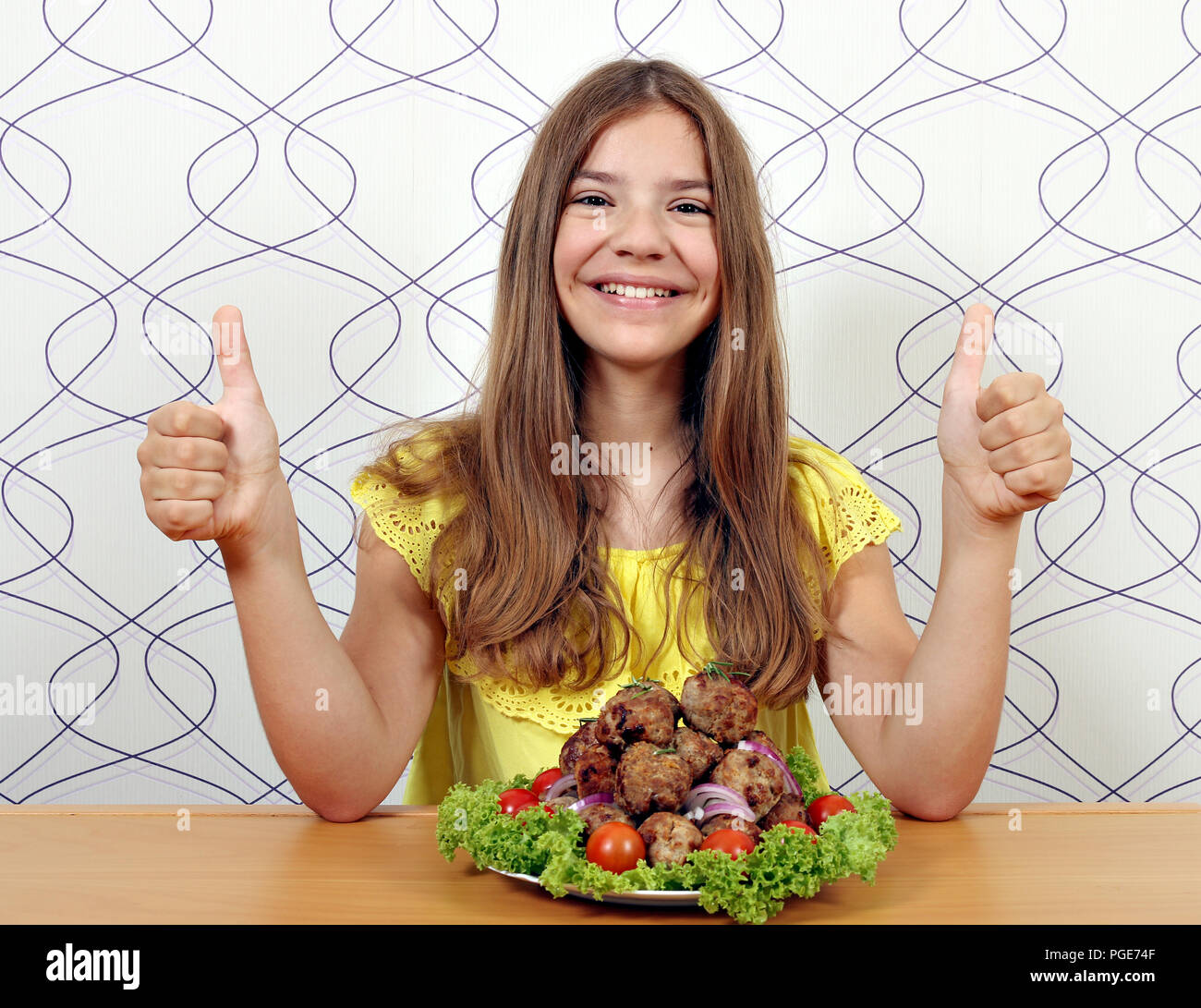 happy girl with meatballs and thumbs up Stock Photo