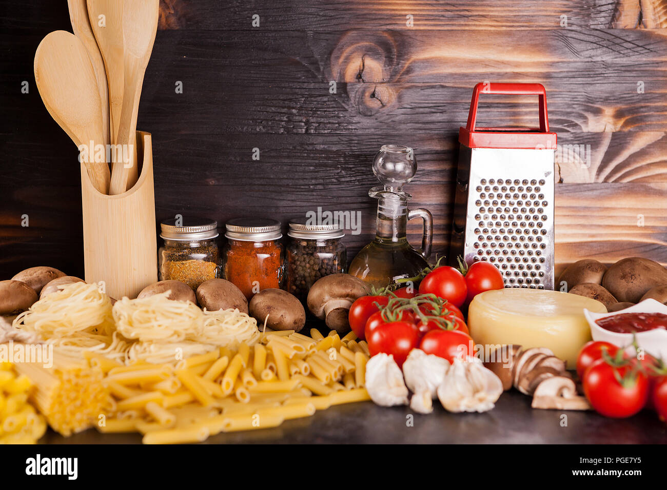 Raw uncooked spaghetti, pasta and macaroni next to fresh vegetables on
