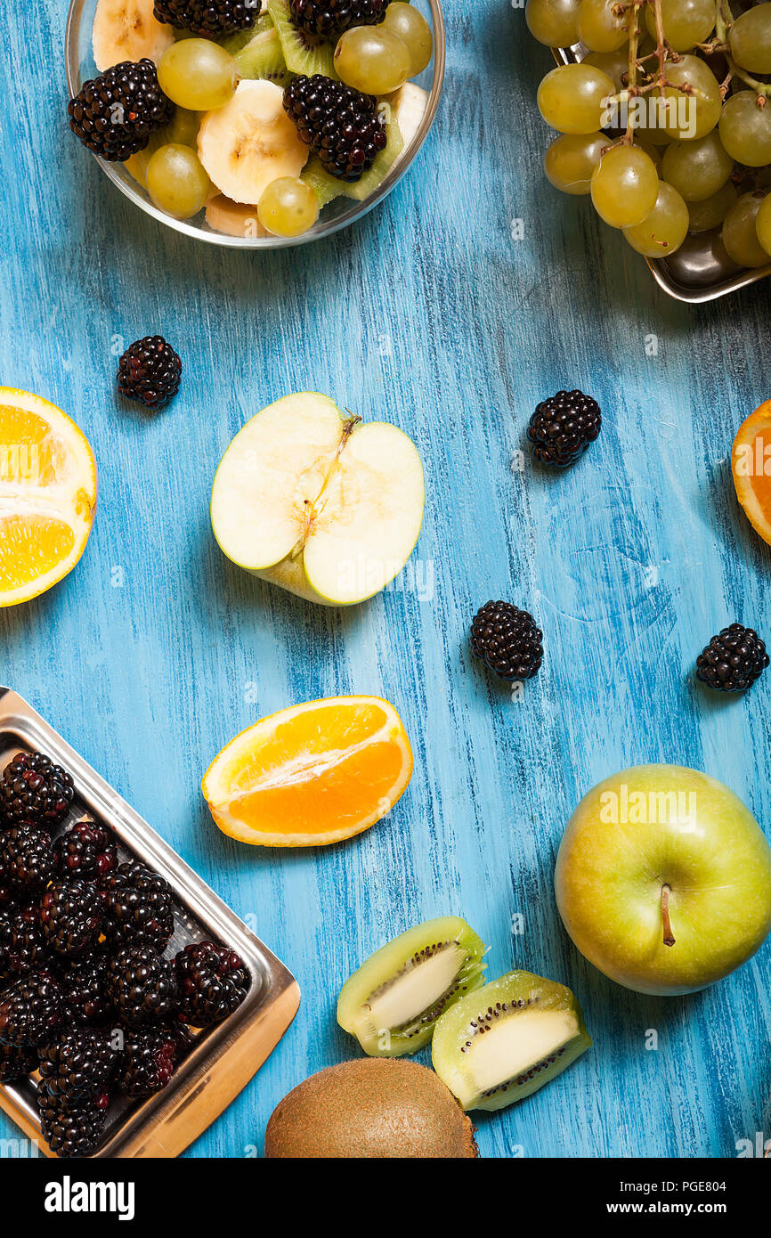 Top view of fruits and barries over a blue desk in studio. Natural ...