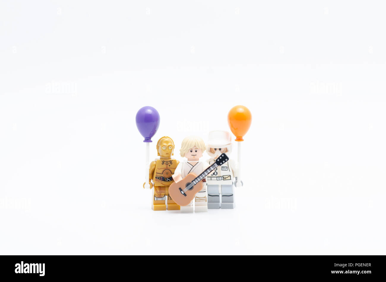 Lego luke skywalker holding guitar with rebel army and c3p0 holding balloon. Stock Photo