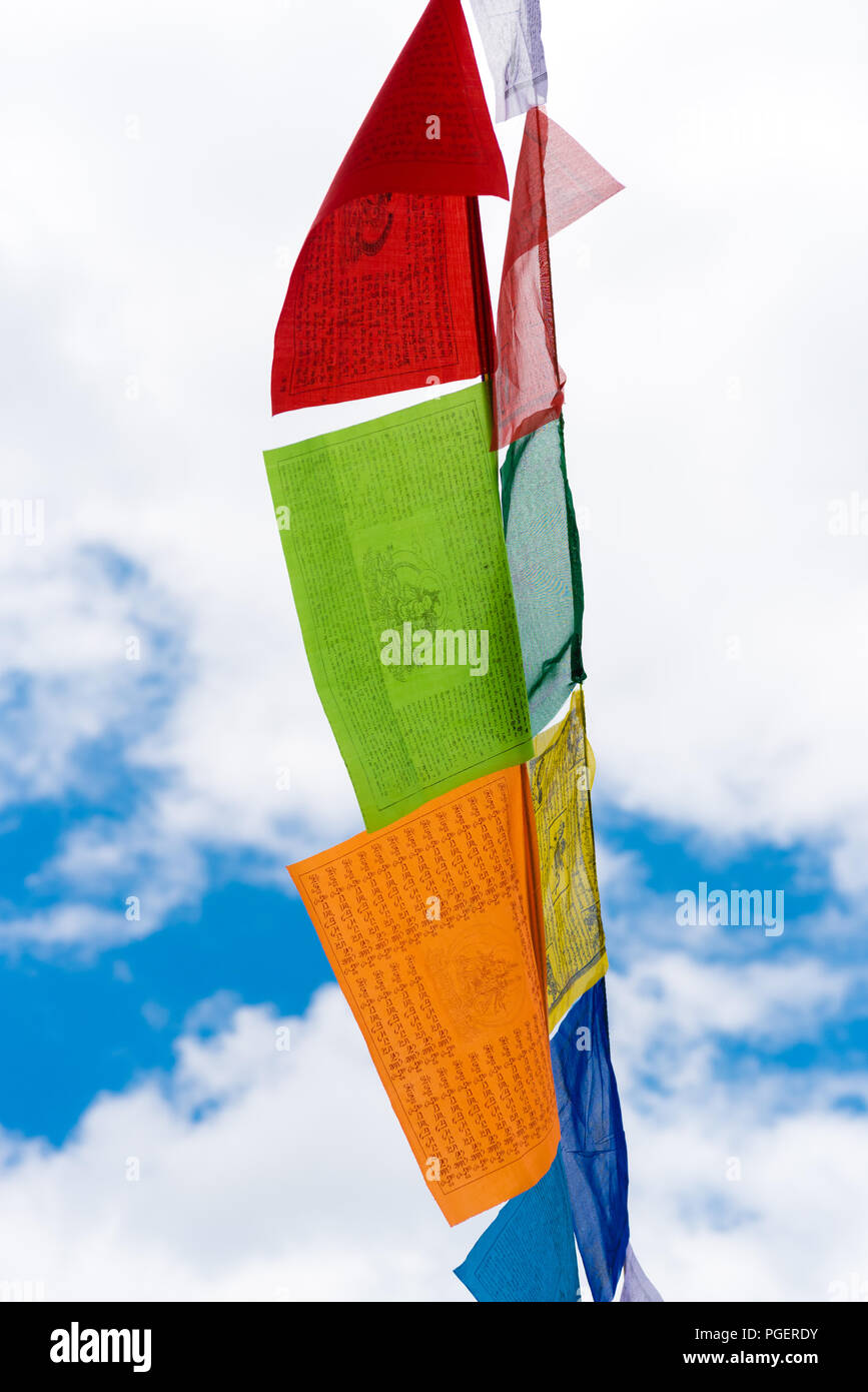 Traditional buddhist prayer flags over blue sky background, are used to ...
