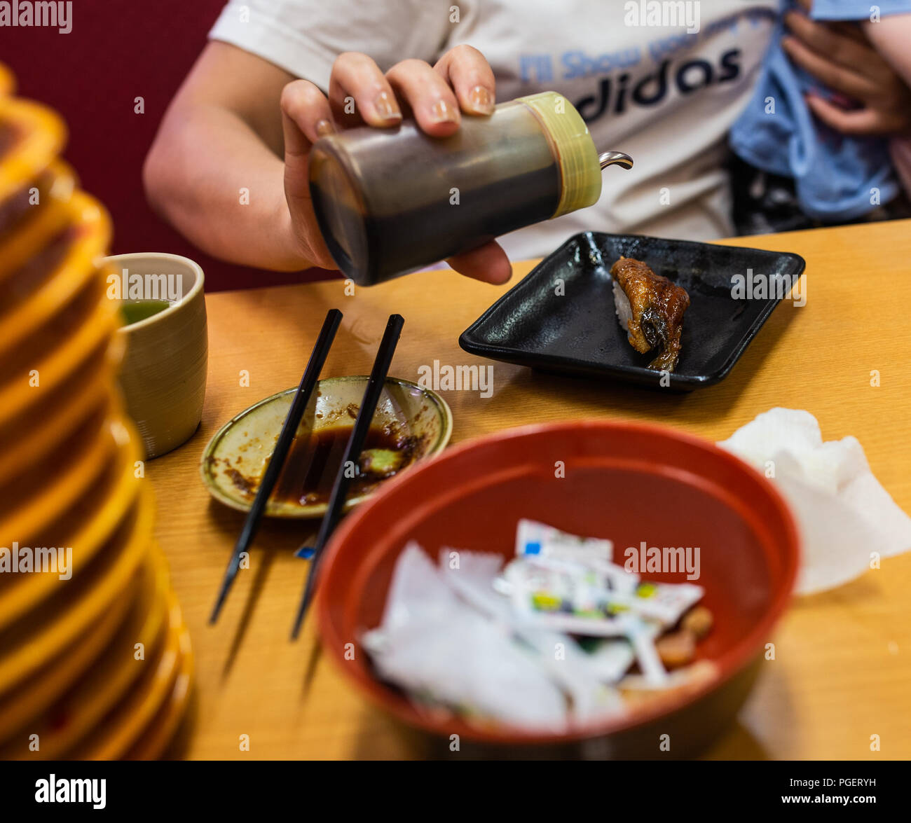 Woman putting soy sauce of sushi Stock Photo - Alamy