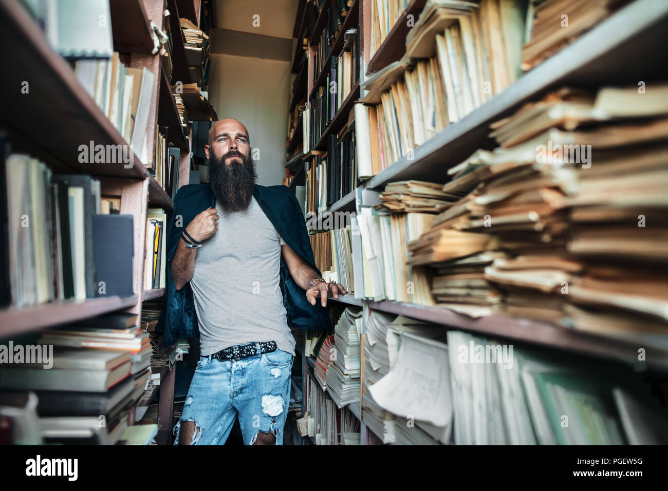 portrait-of-bearded-stylish-hipster-man-in-library-PGEW5G.jpg