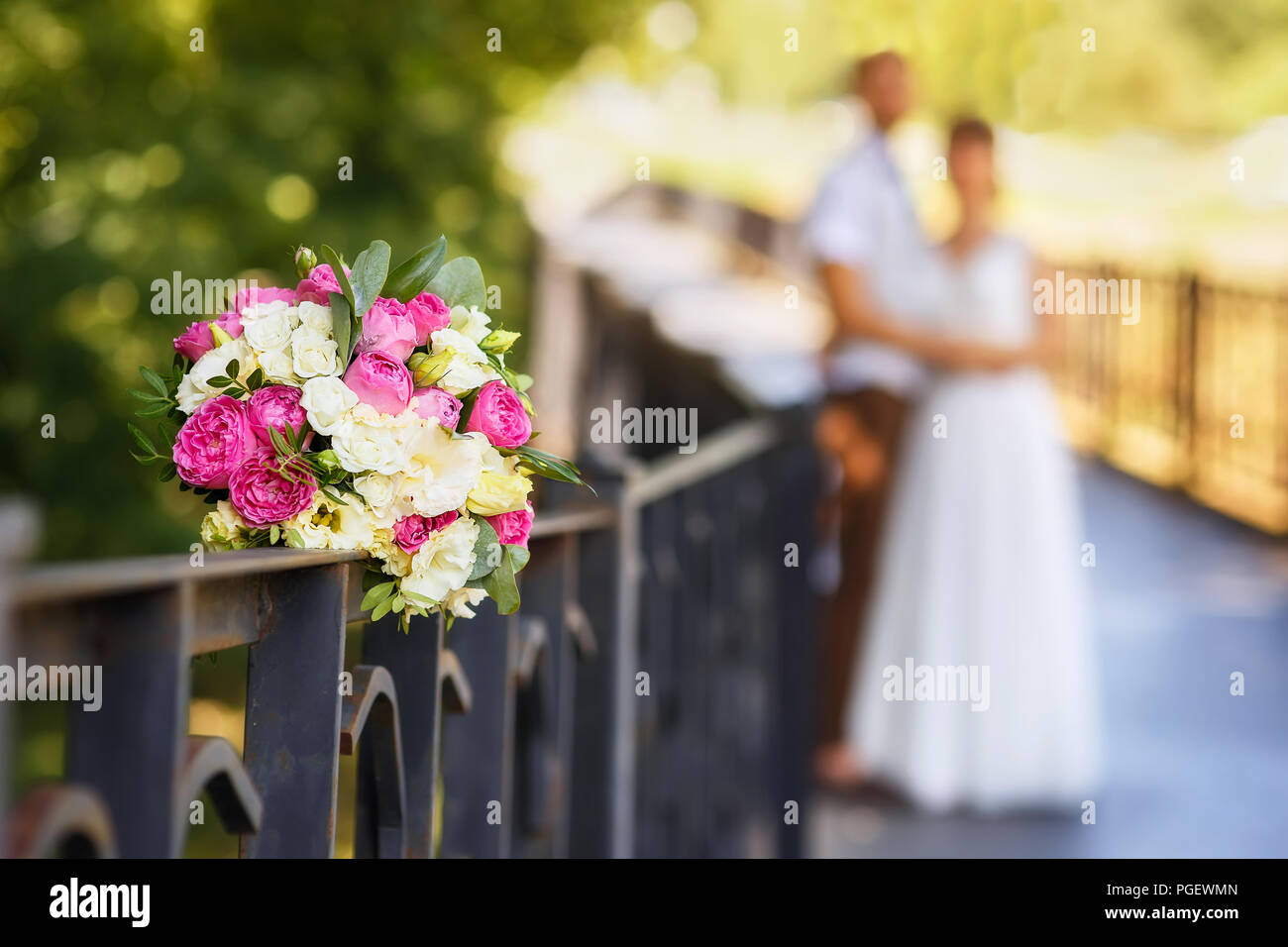 beautiful wedding bouquet in focus on blurred newlyweds couple background  Stock Photo - Alamy