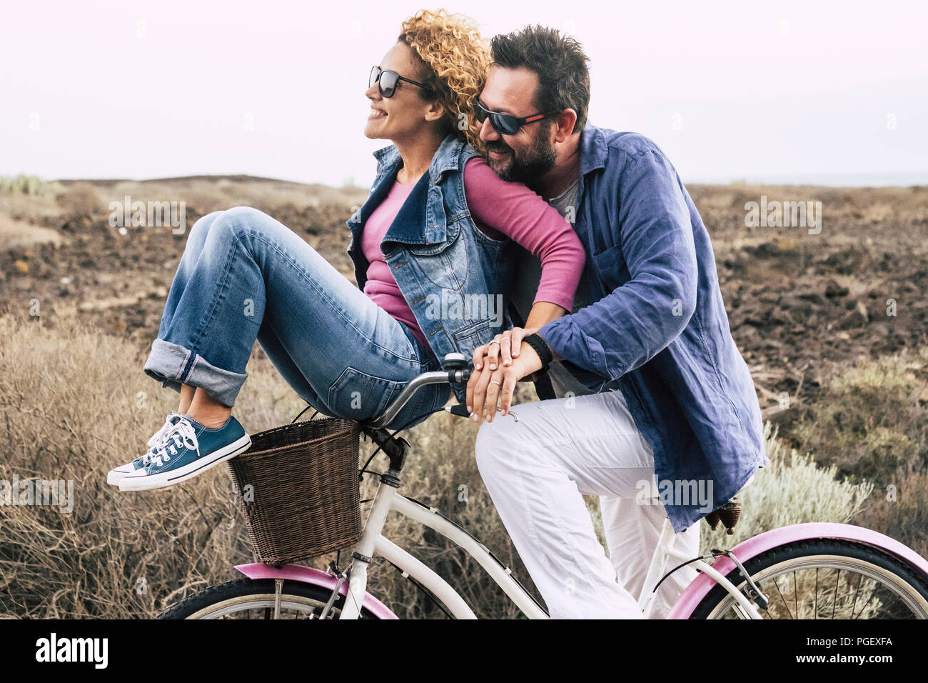 happy adult caucasian, couple having fun with bicycle in outdoor