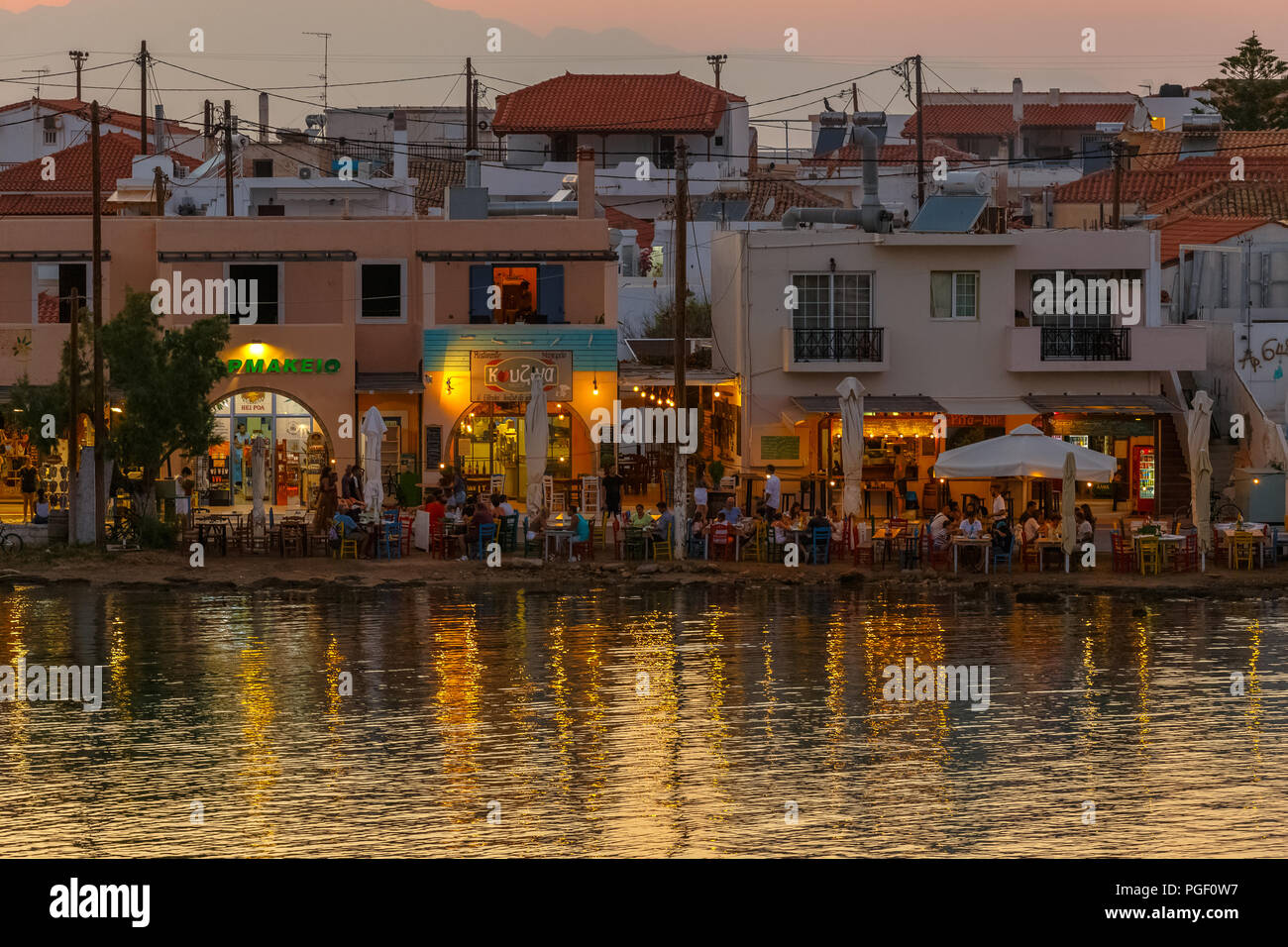 Elafonisos city in distance in the afternoon with restaurants and sea reflections in Lakonia, Peloponnese, Greece Stock Photo