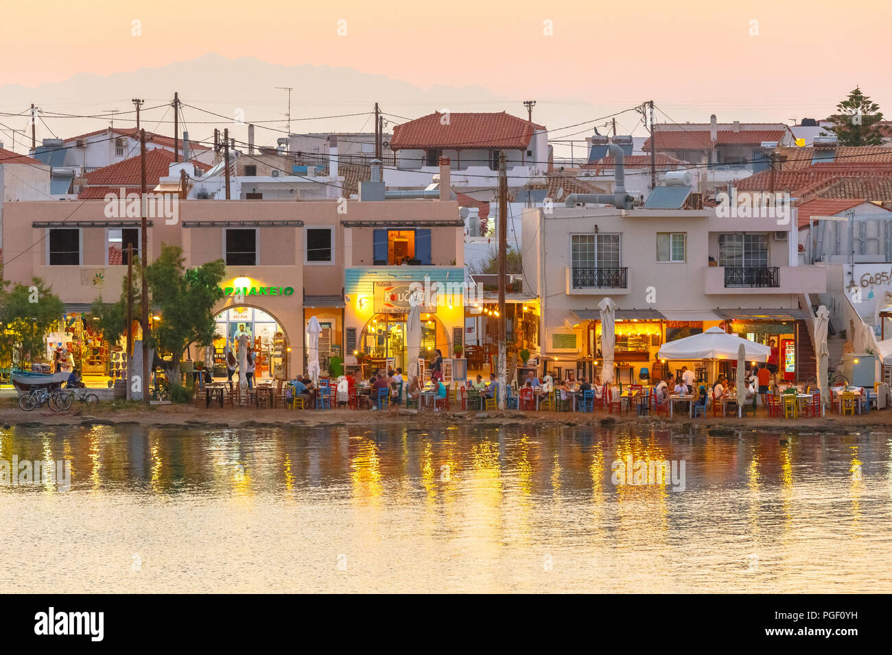 Elafonisos city in distance in the afternoon with restaurants and sea reflections in Lakonia, Peloponnese, Greece Stock Photo