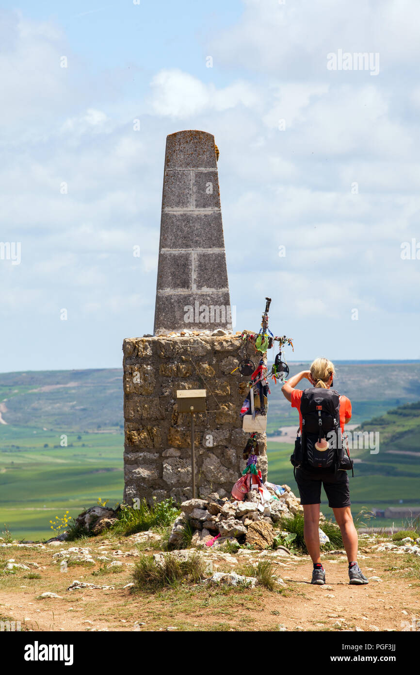 Pilgrim walking the Camino de Santiago the way of St James by the monument at the top of the  Alto de mostelares  just out of Castrojeriz Spain Stock Photo