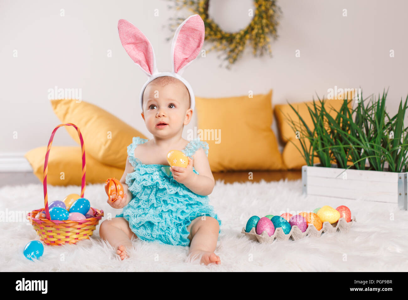 Cute adorable Caucasian baby girl in blue green romper wearing bunny ...