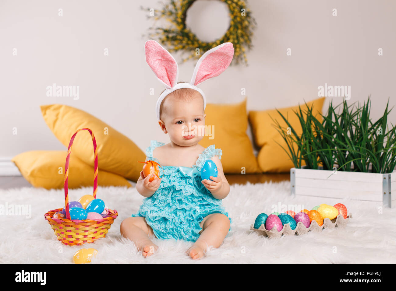 Cute adorable Caucasian baby girl in blue green romper wearing bunny ...