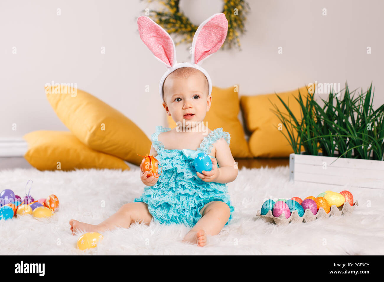 Cute adorable Caucasian baby girl in blue green romper wearing bunny ...