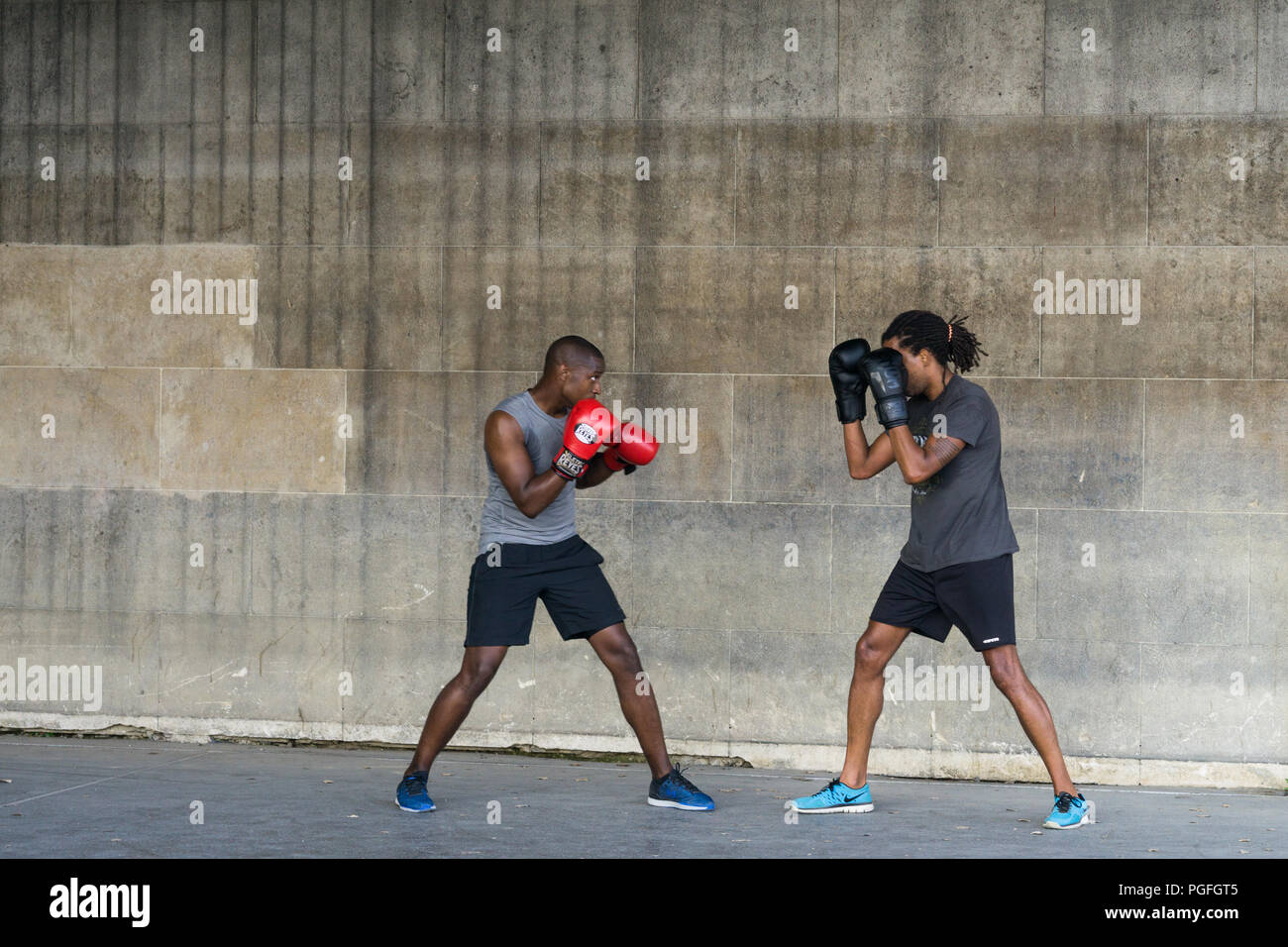 Boxing workouts - Two men in their early 30s working out by boxing outdoors. Stock Photo