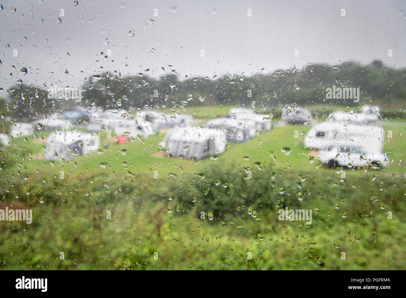 Dorset, UK.  26th August 2018. The Bank Holiday weekend turns soggy for holiday makers in their caravans at Wood Farm Camping and caravanning site as persistent rain and gusty winds replace the previous sunny weather. The rain is forecast to continue all day, clearing overnight. Credit: Julian Eales/Alamy Live News Stock Photo
