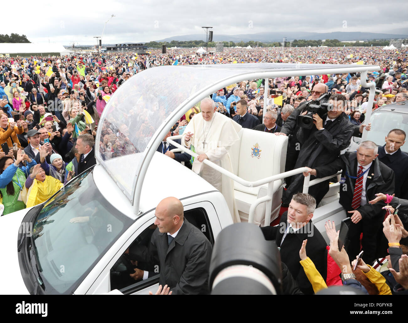26/08/2018 Visit of Pope Francis to Ireland. People from all over the world cheer on Pope Francis as he arrives in the Phoenix Park in his Pope Mobile. Pilgrims came prepared for the wet weather ahead of the Mass to be given by Pope Francis later today, during day two of his visit to Ireland. His visit comes soon after the most recent clerical abuse controversy to rock the Church, as a report claimed that over 300 priests who abused more than 1,000 children in Pennsylvania were protected by the Church - in addition to recent Irish scandals, including reports into the Magdalene Laundries and th Stock Photo