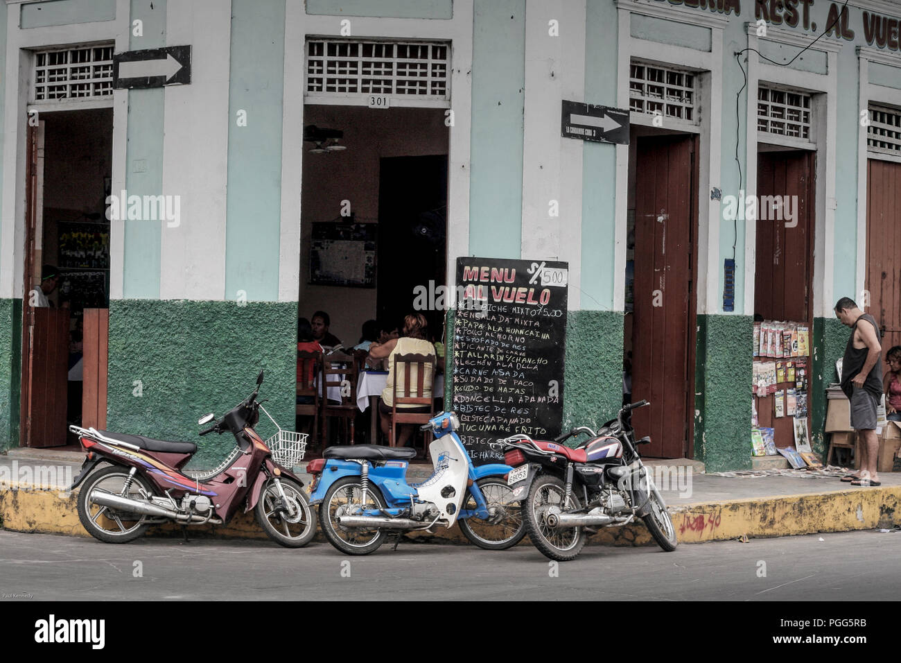 Motorcycle and motor scooters parked outside restaurant in Iquitos, Peru Stock Photo