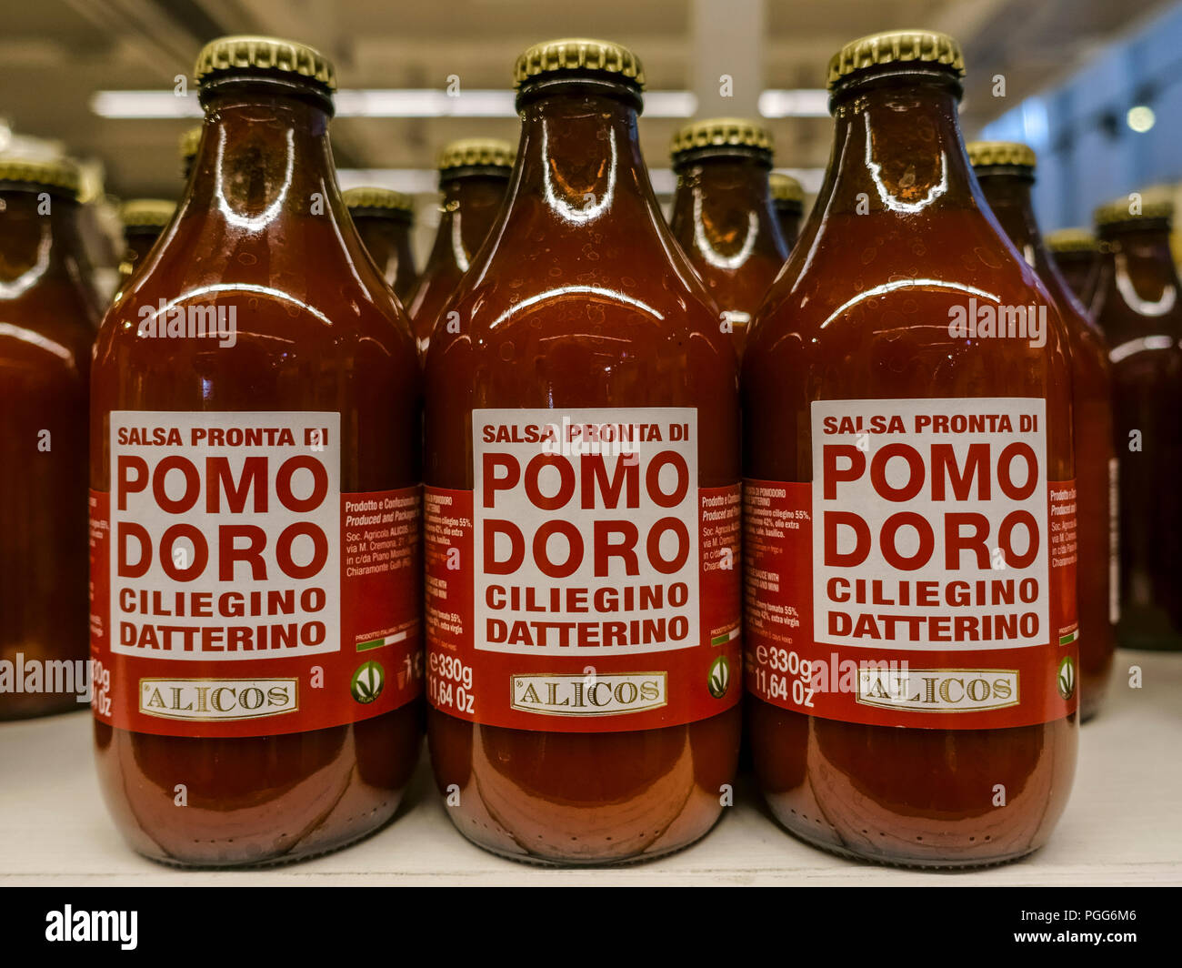 Tomato passata puree sauce for pasta displayed for sale. Peeled tomatoes sauce bottles aligned on a shelf. Mediterranean healthy diet. Close up. Stock Photo