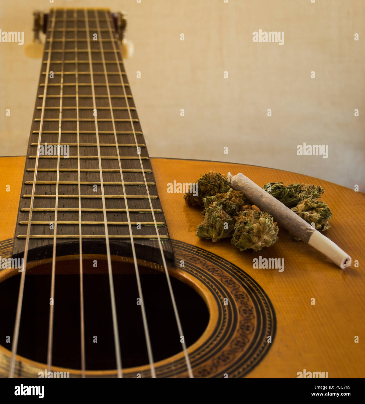 Fretboard and neck of a classical or spanish guitar with marijuana buds and  joint on it. Bright white background with blur effect. Close up view Stock  Photo - Alamy