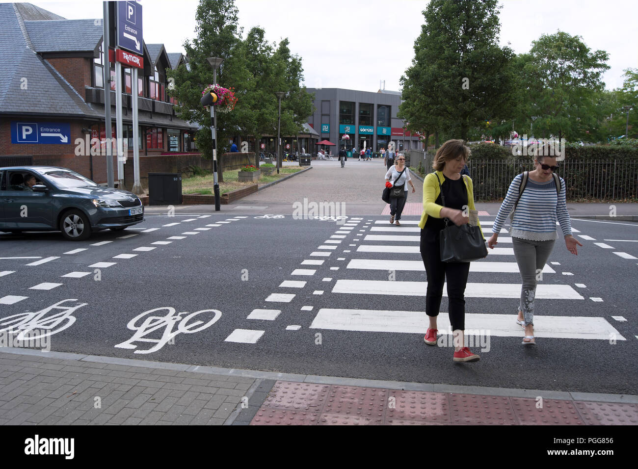 pedestrians cross a zebra crossing adjacent to a tiger crossing, intended for cyclists, in walthamstow, london, england Stock Photo