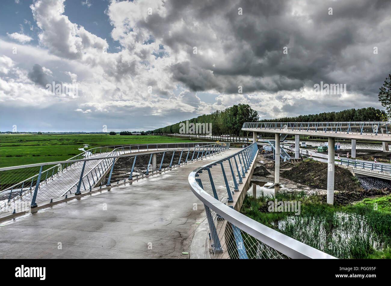 Nigtevecht, The Netherlands, August 25, 2018: view from the hairpin curves leading to the new bridge, with a dramatic sky over polders and long lines  Stock Photo