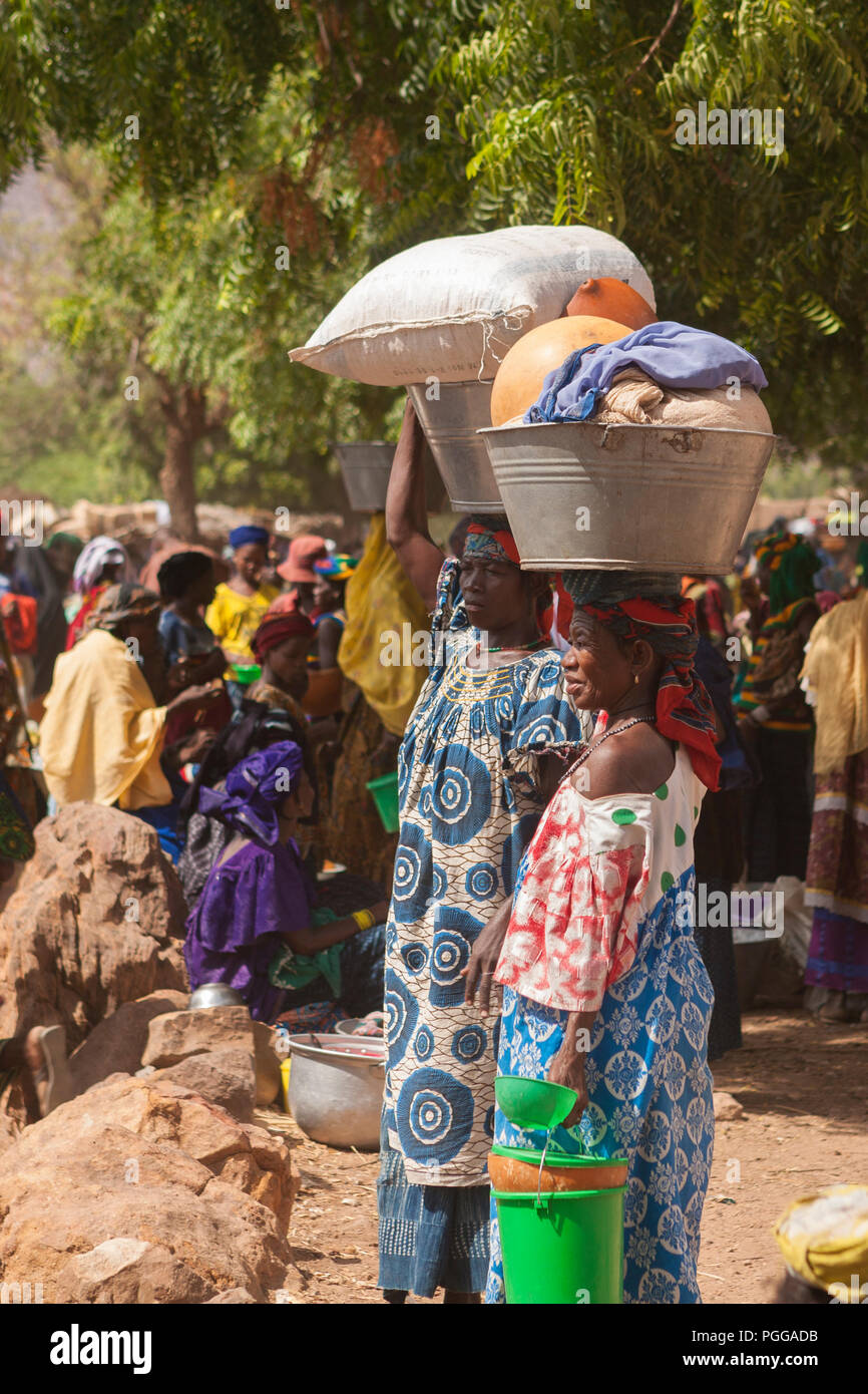 African women carrying basins on head in a street market Stock Photo