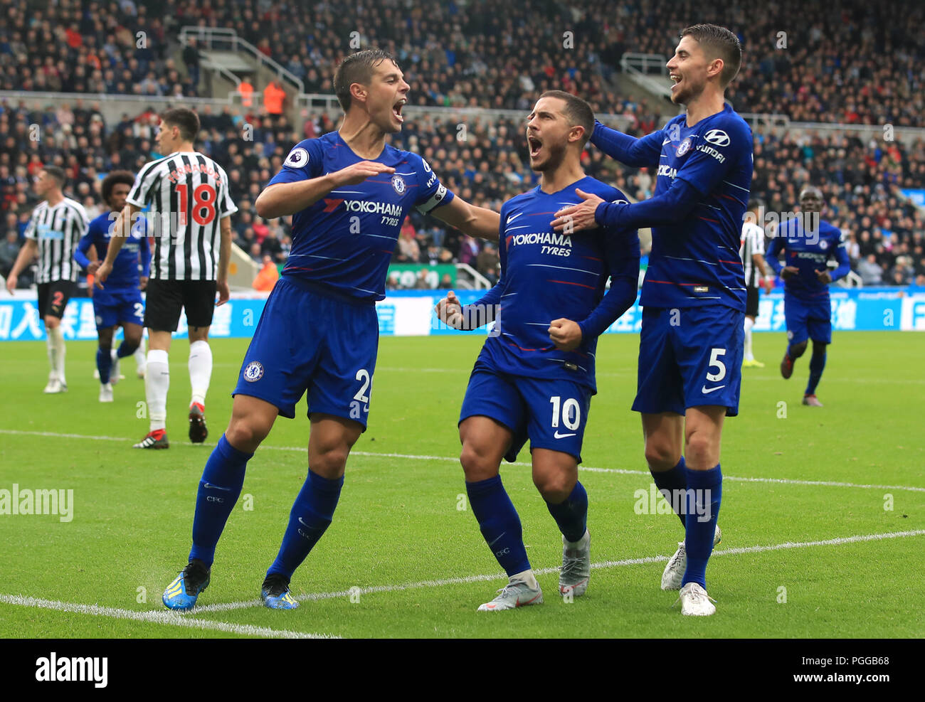 Chelsea's Eden Hazard (centre) celebrates scoring his side's first goal of the game with team-mates Cesar Azpilicueta (left) and Filho Jorge Jorginho during the Premier League match at St James' Park, Newcastle. PRESS ASSOCIATION Photo. Picture date: Sunday August 26, 2018. See PA story SOCCER Newcastle. Photo credit should read: Owen Humphreys/PA Wire. RESTRICTIONS: No use with unauthorised audio, video, data, fixture lists, club/league logos or 'live' services. Online in-match use limited to 120 images, no video emulation. No use in betting, games or single club/league/pla Stock Photo