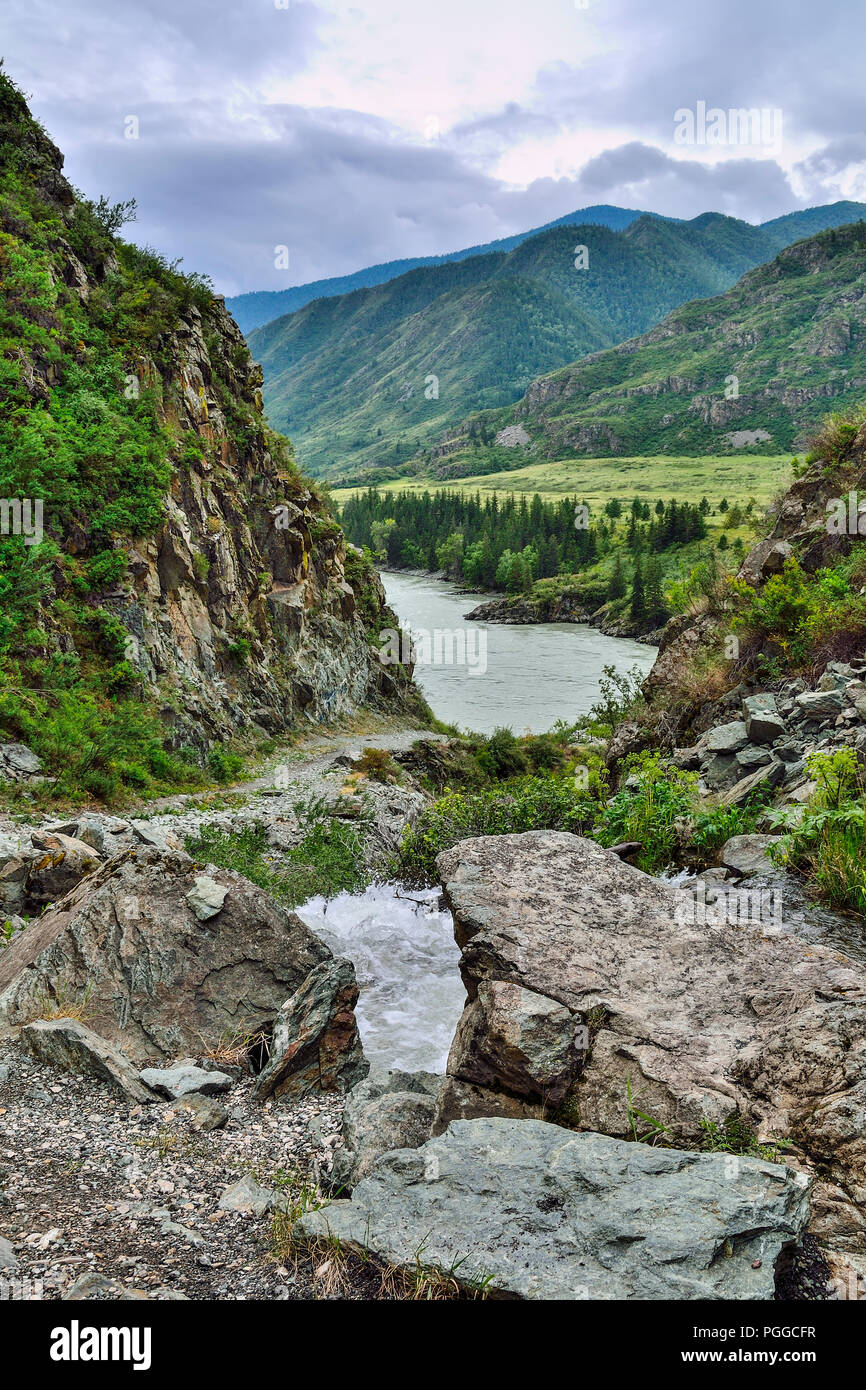 Mountain creek with waterfalls flowing under cliffs of canyon among boulders into the Katun River in Altai mountains, Russia - beautiful summer landsc Stock Photo